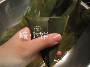 剩余粽叶翻折过来包好，用棉绳捆紧
