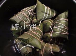 煮熟。我是加水至没过所有粽子，电高压锅上汽后30-40分钟，自然放气后开盖
一次做得多吃不完，我是煮熟沥水放凉后，再放冰箱冷冻保存