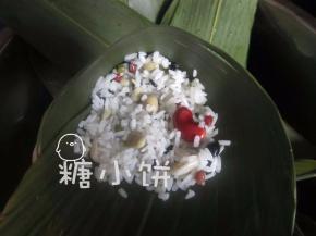 填入一部分步骤2拌好的各种米料，填到圆锥筒的一半位置