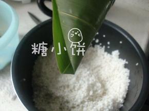 注意底部是有一个褶的，这样不怕锥形尖尖的那个位置漏米。
这个褶可以在外面也可以在里面，这次的这个样子是在外面的。
在外面的好处是，成品粽子剥开来尖是尖角是角的，不怕被这道褶压出个缺。
留粽叶褶在里面的话可能会压出一道痕迹，但好处是捆绳子的时候更顺手。