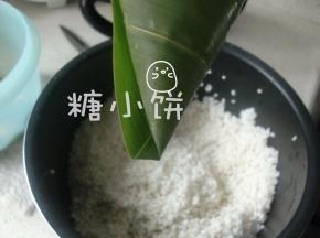 注意底部是有一个褶的，这样不怕锥形尖尖的那个位置漏米。
这个褶可以在外面也可以在里面，这次的这个样子是在外面的。
在外面的好处是，成品粽子剥开来尖是尖角是角的，不怕被这道褶压出个缺。
留粽叶褶在里面的话可能会压出一道痕迹，但好处是捆绳子的时候更顺手。