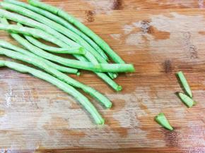 豇豆掐去头尾，撕去丝