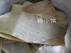 干粽叶用清水泡软后刷洗赶紧，煮5-10分钟，剪去硬梗部分备用
粽叶最好是选择宽而大的，这样包出来的形状不会太过于细，也容易包严实