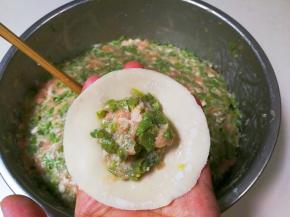 取一张饺皮放入适量馅包起来，下锅煮熟