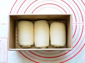 把卷好的面团排入土司盒中。