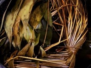 竹叶先泡在水里30分钟，然后用刷子逐片刷干净，两面都要认真刷。然后和绳子一起放入装满水的大锅里煮15分钟。使竹叶杀菌同时变得柔软有韧性。