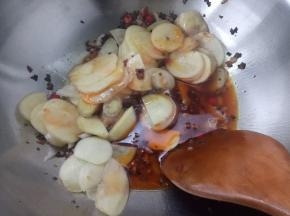 放入土豆片和洋葱碎翻炒几下，加少许的生抽和盐，再加一点点水盖上盖子中火焖5分钟。
