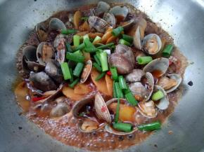 开盖后放入剩下的蚬子，放点小葱翻炒几下关火。