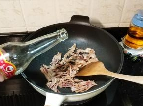 倒入米酒炒至土鱿卷起