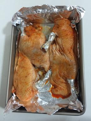 深烤盘铺上一层锡纸，把腌制好的半片鸭放在烤盘里，把鸭腿用锡纸包住，以免烤的时候糊了。