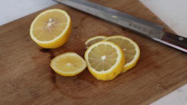 取一个柠檬，一半切片，另一半挤出柠檬汁备用
