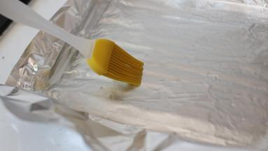 烤盘上铺好锡纸，要裁的大一些。用硅胶毛刷薄薄的刷一层油