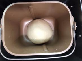 把面团滚圆，放入面包机桶中