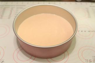 在剩余的蛋糕糊内滴入一至两滴的红丝绒液，拌匀后倒入一半的蛋糕糊到模具内，震平