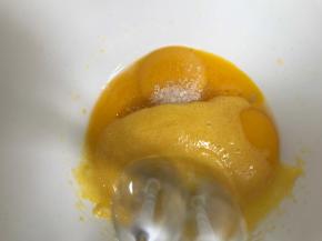 把剩下的白糖加入蛋黄中，再加入玉米油，低档打至糖融化