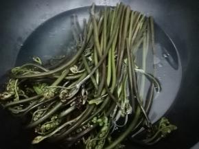 锅里放入水，少许的盐和油烧开，再把蕨菜放入锅中炒水