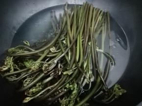 锅里放入水，少许的盐和油烧开，再把蕨菜放入锅中炒水