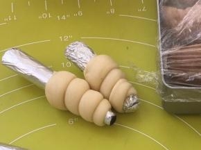 以后绕着锡纸棒旋转，最后头的部分藏在上一个旋转的面条里面，捏紧