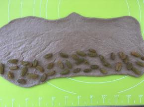 在面团的一侧铺上适量的葡萄干