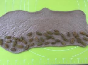 在面团的一侧铺上适量的葡萄干