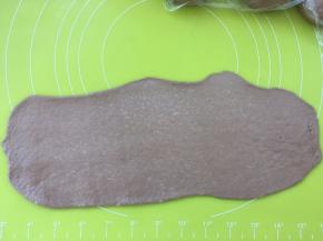 取一份松弛好的面团，用擀面杖擀成长条，长度是28乘28方盘的长度