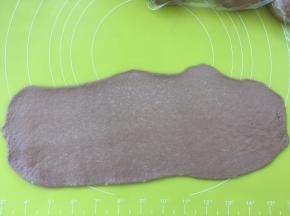 取一份松弛好的面团，用擀面杖擀成长条，长度是28乘28方盘的长度