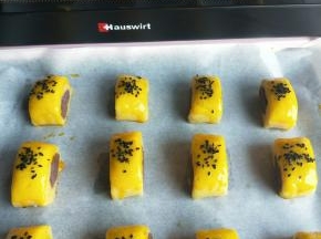 刷上蛋黄水，撒上黑芝麻。