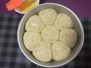 面团发酵至2倍大取出，刷蛋液，撒上杏仁片。烤箱上下火170度预热10分钟。