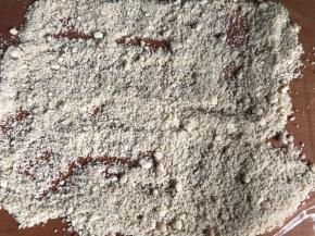 把熟花生和熟芝麻糖放入保鲜膜上，铺平