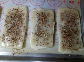 赶紧撒上芝麻，用手按压一下这样就粘牢了（最好刷一个撒一个，要不干了就粘不住芝麻了）