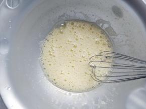 接下来制作饼干部分：将鸡蛋和细砂糖，牛奶一起倒入打蛋盆中，用打蛋器搅拌到糖完全融化。