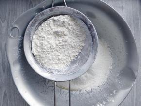 筛入低筋粉和泡打粉的混合物，加入橙皮屑，拌匀到光滑的面团。