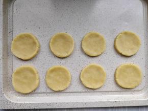 取出圆柱形的面团，切成厚度约5mm的圆形厚片，在不粘烤盘上摆好。