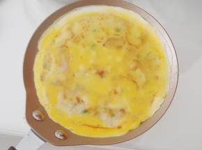 一面煎熟后翻面，磕上适量打散的鸡蛋