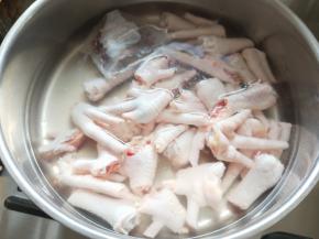 准备一个深一些的锅，倒入清水，将鸡爪和卤料袋放入