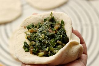 包入一勺肉馅，尽量饱满一些。就像包包子一样包起来，不需要有褶子，只要不露馅就好。