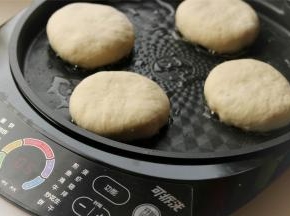 电饼铛烤盘刷一层油，上下烤盘都刷一些。放入做好的馅饼，馅饼别按的太薄，靠电饼铛把它压薄，会比较均匀，上色也好看。