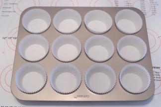 准备一个12连的圆形杯子蛋糕模具，放入纸托