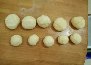 把面团充分排气，留出六分之一左右的面团做装饰用，剩下的分成五个大剂子做圣诞娃娃的身子，还有五个小点的剂子做脸蛋。