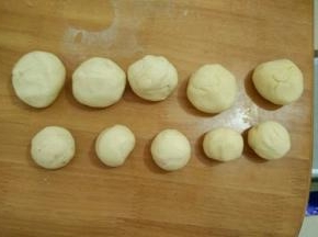 把面团充分排气，留出六分之一左右的面团做装饰用，剩下的分成五个大剂子做圣诞娃娃的身子，还有五个小点的剂子做脸蛋。