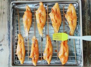 把孜然倒入碗中，用刷子适量刷在冰鱼上