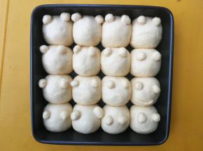 将小眼睛面团底部粘点水，粘在大面团的合适位置上，然后送入烤箱开启发酵模式进行二发，发酵至两倍大小