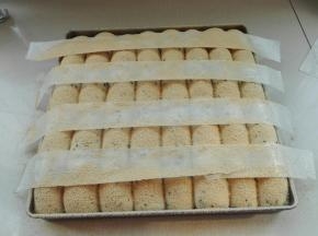 发酵好后，用长条油纸如图摆放，筛入黄豆粉