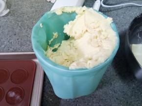 裱花袋装好曲奇花嘴，用一个宽口杯子撑起来，把面糊挖进裱花袋里