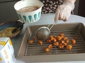 炸好的鸡米花捞出放在滤油盘里。