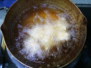 一个个挤出来放入油锅炸制，可以调火力再稍微大一点