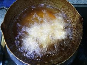 一个个挤出来放入油锅炸制，可以调火力再稍微大一点
