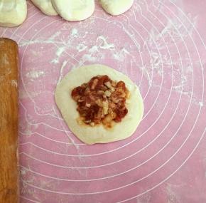 用擀面杖擀成四边薄，中间厚的片，放上馅料。