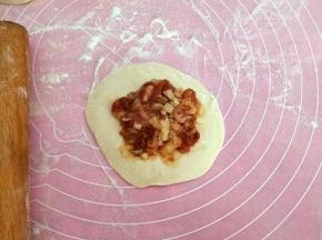 用擀面杖擀成四边薄，中间厚的片，放上馅料。