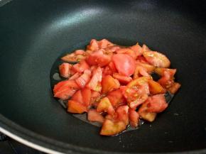 锅里面倒入少许的油，下西红柿块。